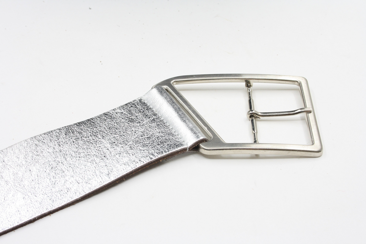 Afdelingriemen.nl zilverkleurige damesriem met een opvallende geometrische gesp en een subtiele metallic textuur.