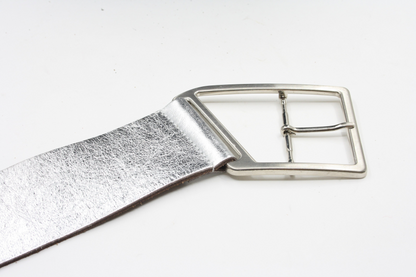 Afdelingriemen.nl zilverkleurige damesriem met een opvallende geometrische gesp en een subtiele metallic textuur.